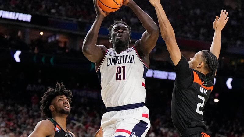 Connecticut forward Adama Sanogo scores past Miami guard Isaiah Wong during the second half of...