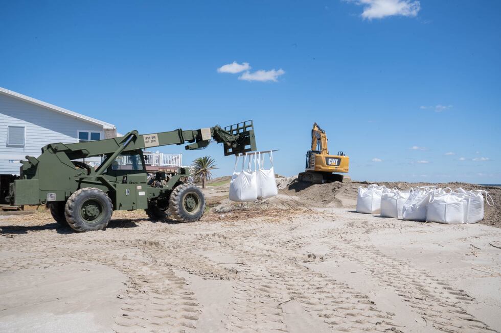 Louisiana National Guardsmen assigned to the 225th Engineer Brigade emplace 3-by-3 foot sacks...