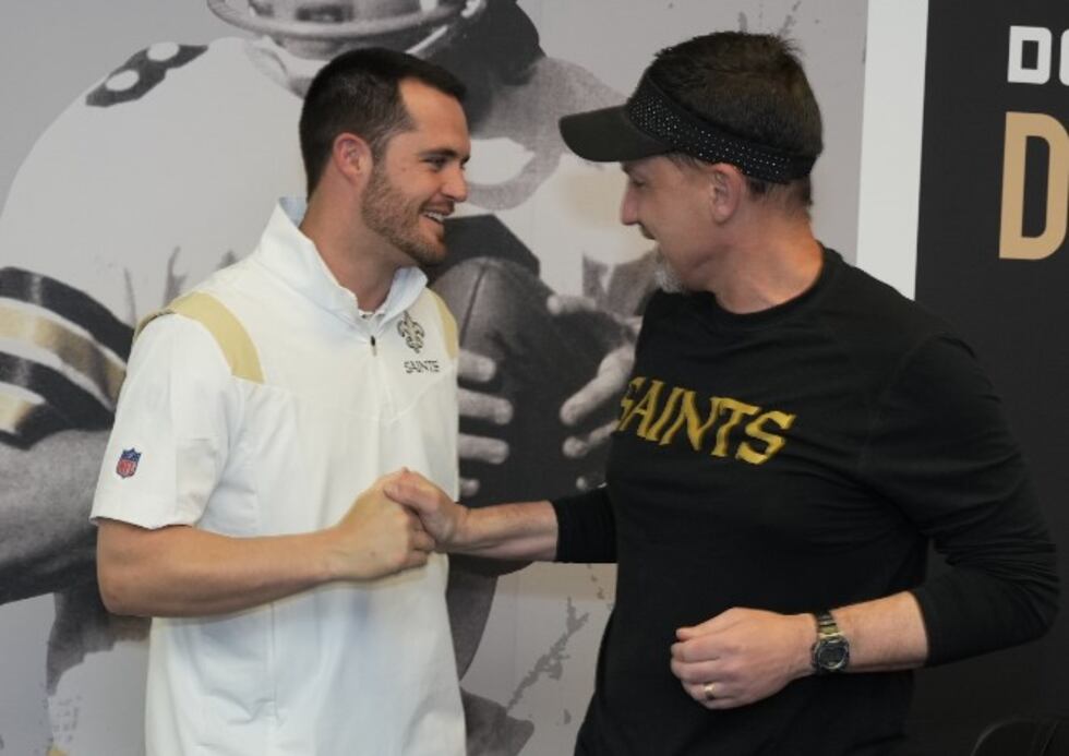Quarterback Derek Carr, left, shakes hands with Saints head coach Dennis Allen after formally...