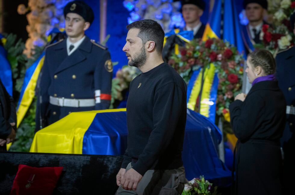 Ukrainian President Volodymyr Zelenskyy pays his respects to victims of a deadly helicopter...