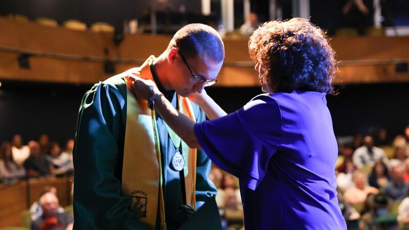 Cadet Hayden Ryals, of Marksville, Louisiana, receives a medal from Mrs. Audra Desselles,...