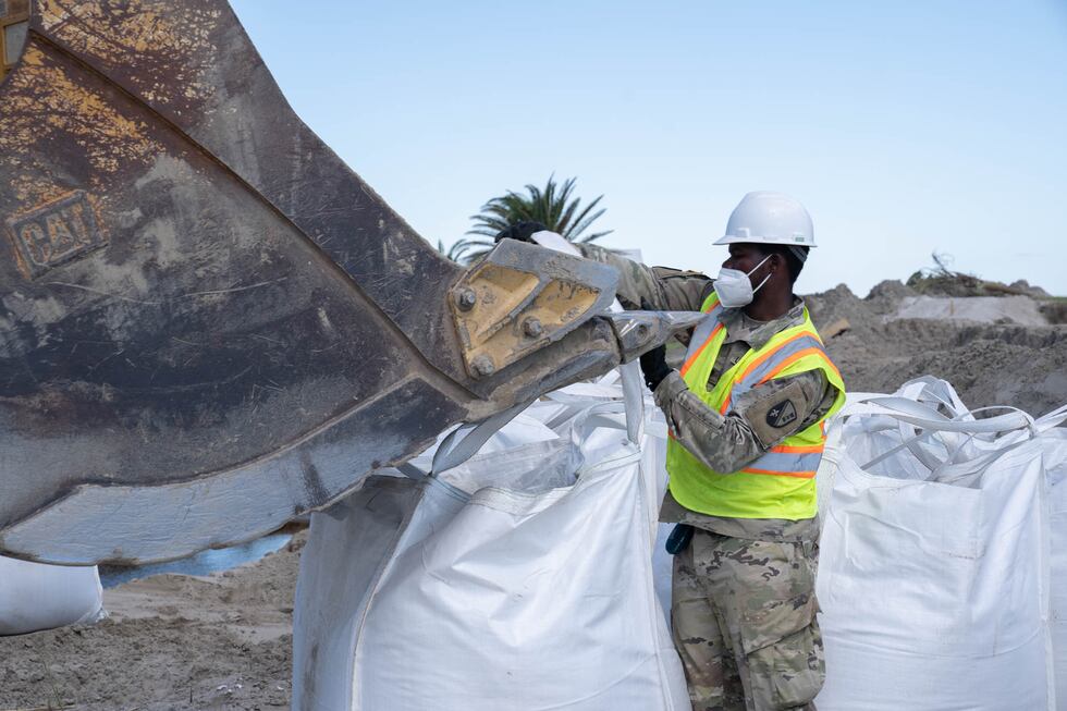 Louisiana National Guardsman assigned to the 225th Engineer Brigade hooks straps of a 3-by-3...