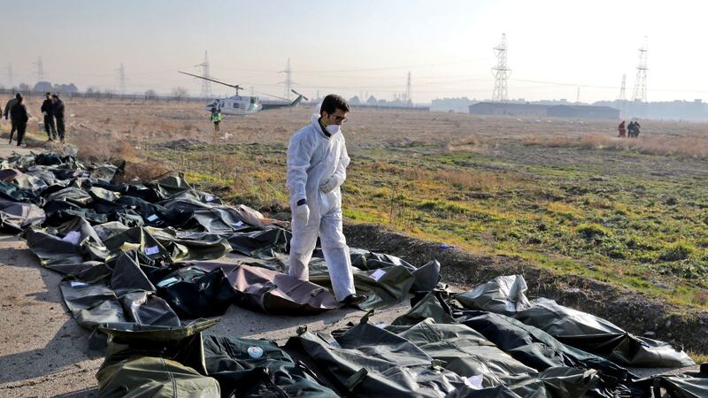 A forensic investigator works at the scene of a Ukrainian plane crash as bodies of the victims...