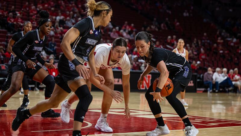 Carla Celaya (right) grabs a loose ball in game against Nebraska.