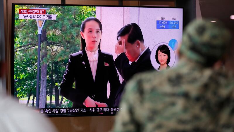 A man watches a TV screen showing a news program with a file image of Kim Yo Jong, the...