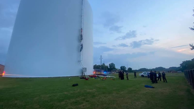 Firefighters climbed the tank to convince the woman swimming inside to come to them. They were...