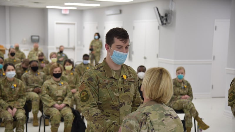 Brig. Gen. Cindy Haygood, the dual status commander of Task Force COVID, congratulates an...