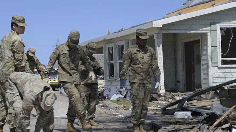 Louisiana Army National Guardsmen assist the citizens of Arabi, Louisiana, by removing debris...