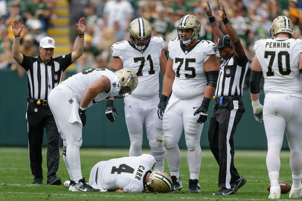 Saints quarterback Derek Carr (4) lays on the turf with a shoulder injury after being sacked...