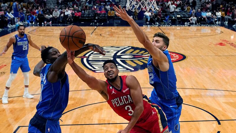 New Orleans Pelicans guard CJ McCollum (3) goes to the basket between Dallas Mavericks...