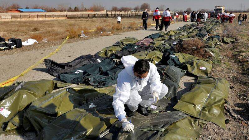 A forensic investigator works at the scene of a Ukrainian plane crash as bodies of the victims...